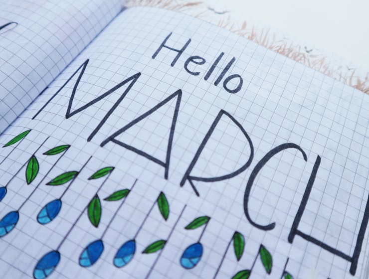 Open notebook with "Hello March" illustration featuring colorful raindrops and leaves.