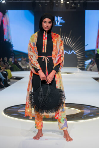 Marina Swimwear Runway at Abu Dhabi Modest Fashion Week, model wearing black and orange burkini with matching kimono.