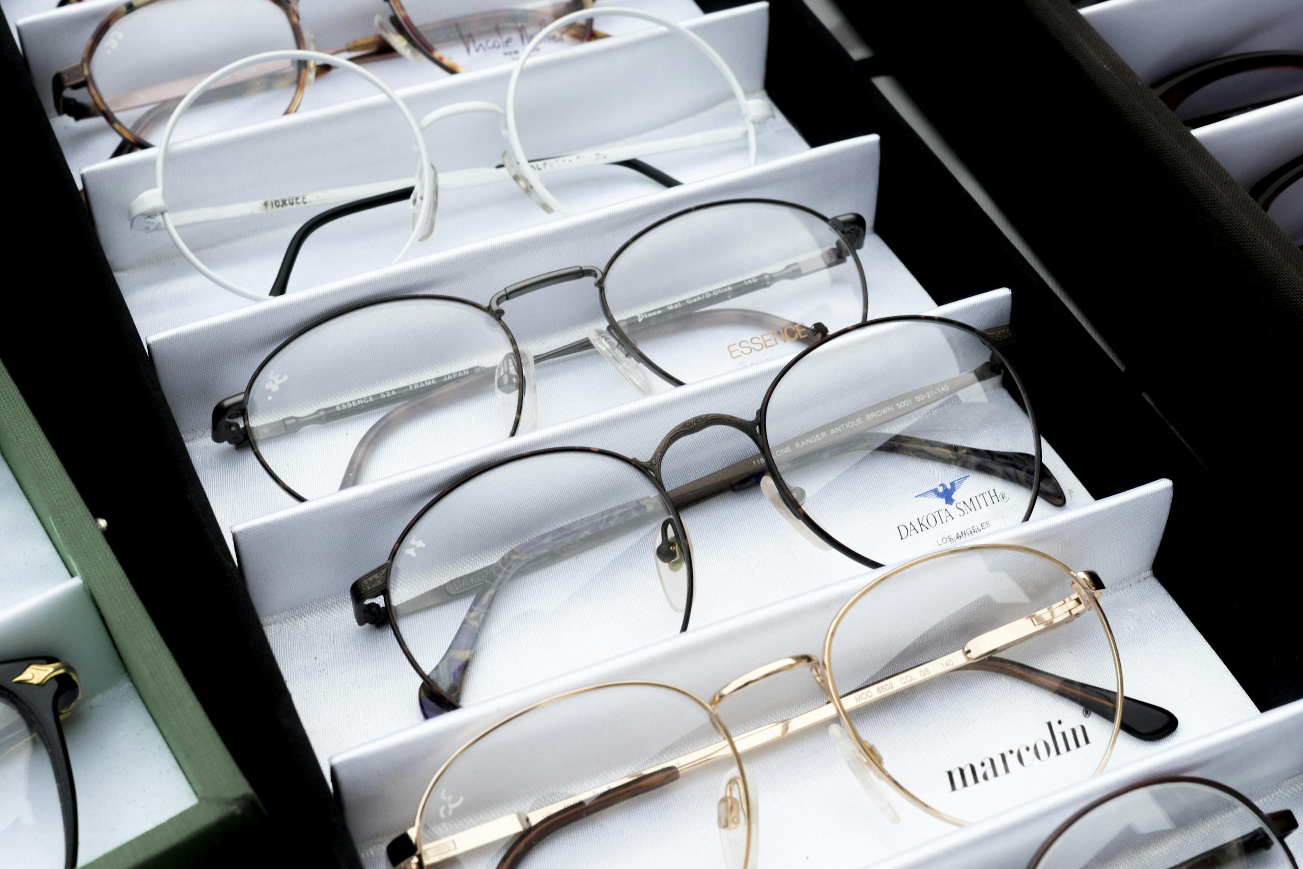 Close-up of assorted eyeglasses showcased in an orderly fashion for selection. Prescription Specs 