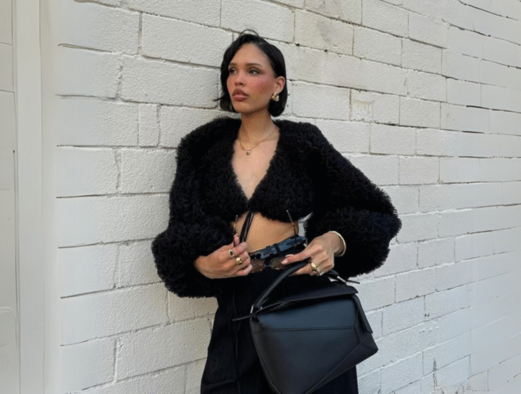 Nara Smith wearing black outfit and minimal makeup - seen on white wall.