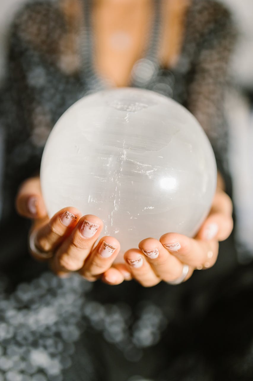 October 2025 HoroscopesClose-up of hands holding a clear crystal ball, ideal for spiritual or metaphysical themes.