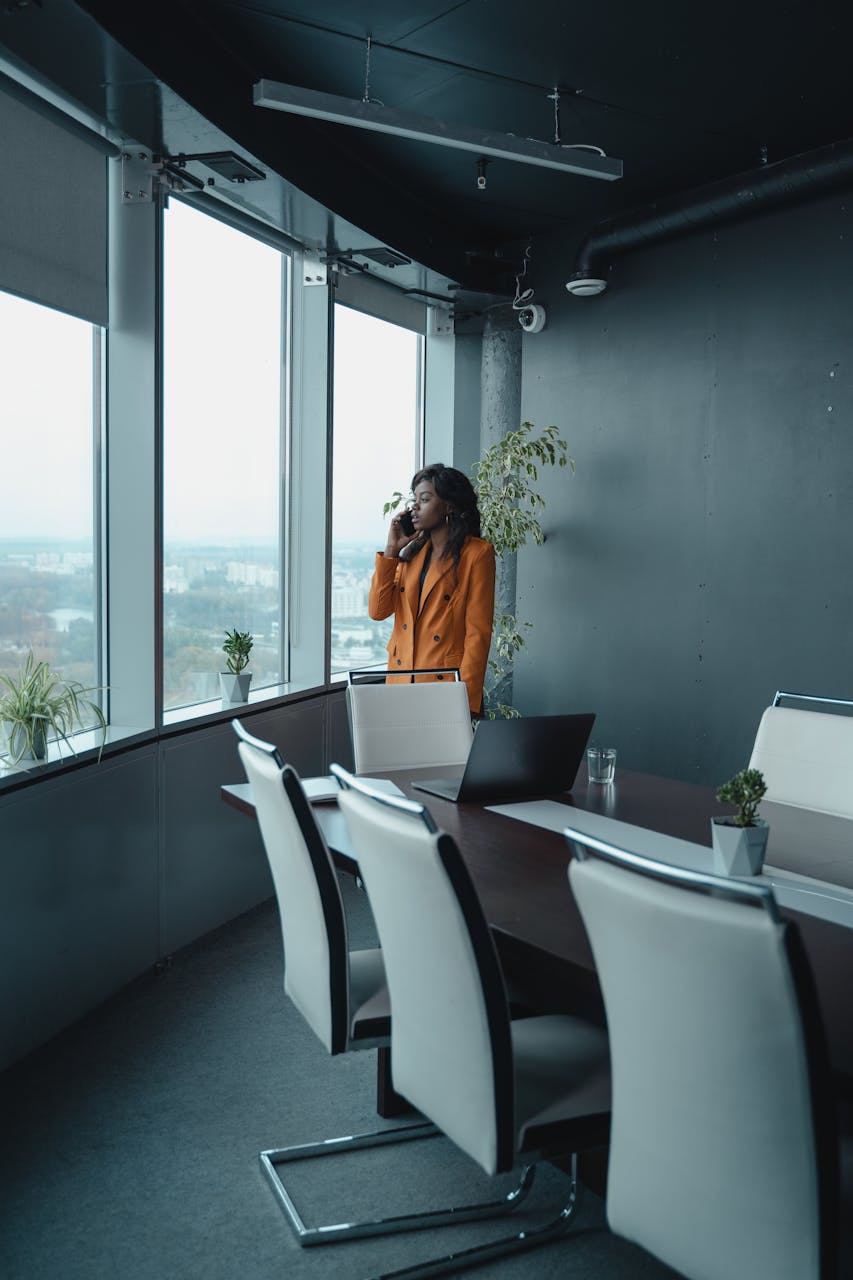 The Massenet Effect & The Future of Fashion Tech 2026A professional woman in an orange blazer talks on her phone in a stylish office.