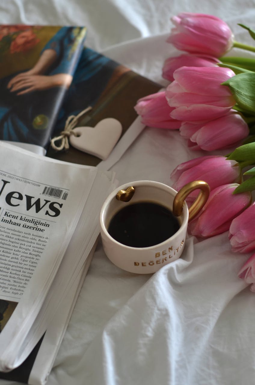 April 2026 HoroscopesApril 2026 HoroscopesA cozy morning scene featuring coffee, pink tulips, and a newspaper on a bed.