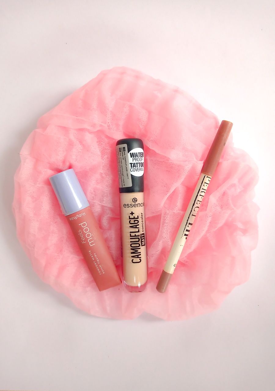 Understanding Makeup EssentialsA minimalist flat lay of various makeup products on a pink fabric background.