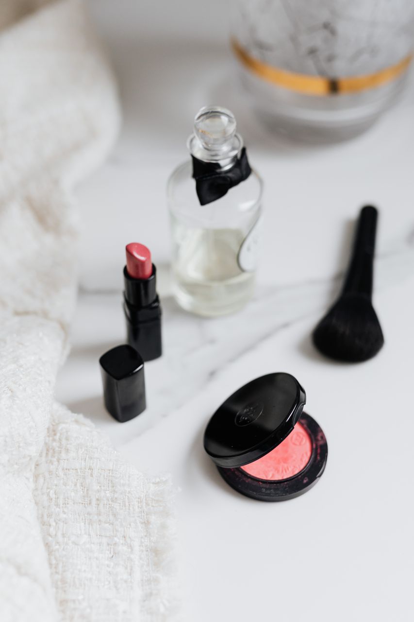 Understanding Makeup EssentialsA flat lay of beauty products including lipstick, blush, and a perfume bottle on a marble surface.