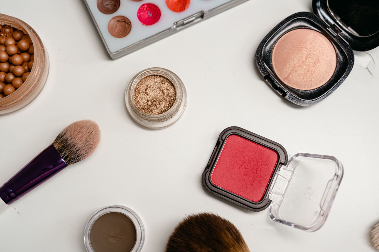 Understanding Makeup EssentialsFlat lay of various makeup products including brushes, powders, and creams on a white surface.