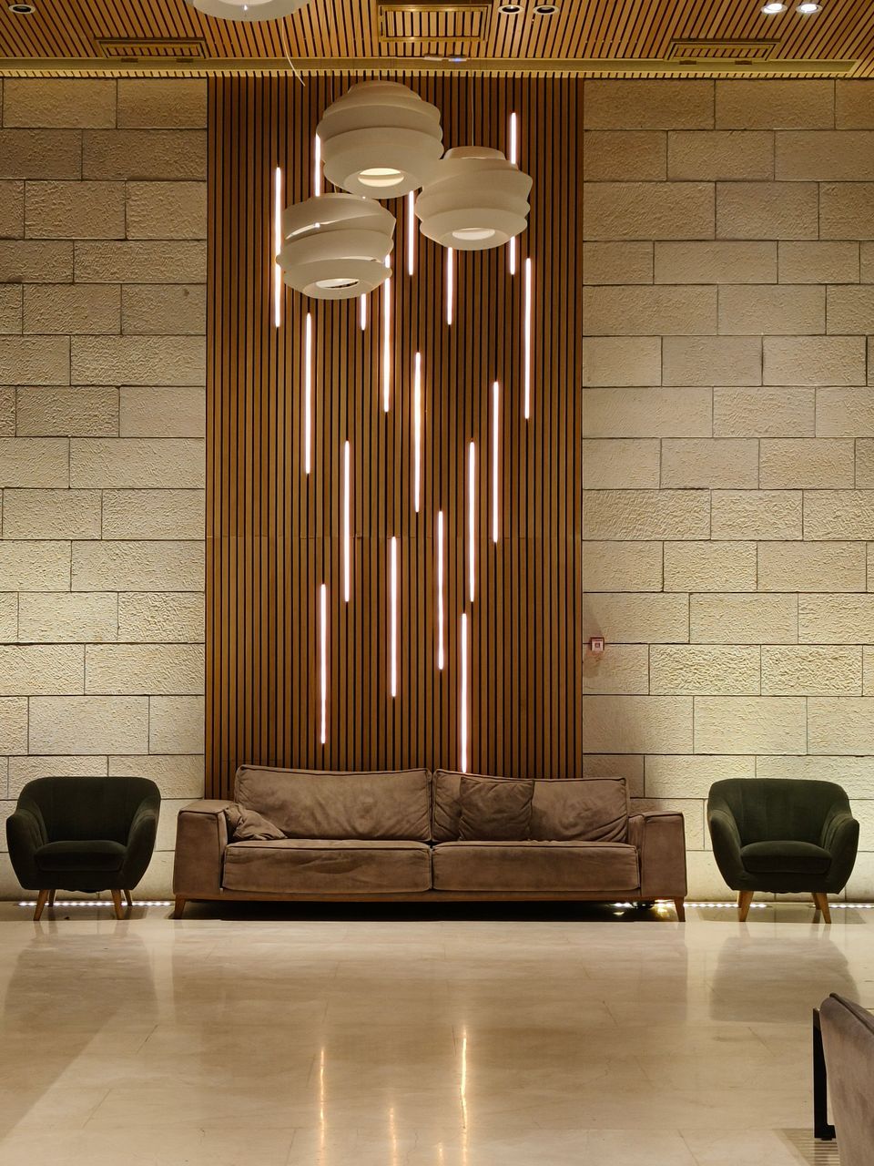 Contemporary living room featuring a cozy sofa, chic armchairs, and modern lighting design.